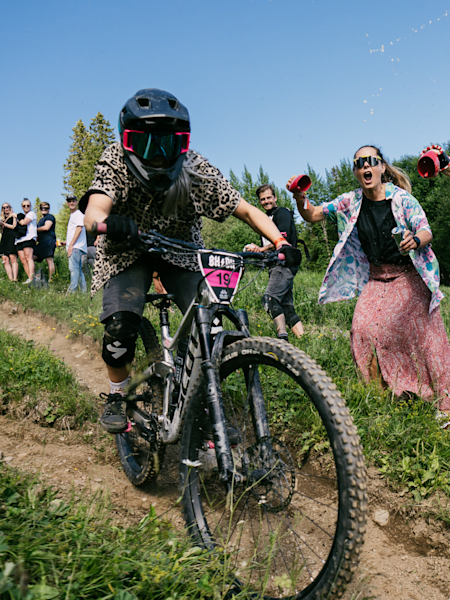 A downhill racer getting cheered on by the crowd during BHDH race at Åre Bike Festival 2021.