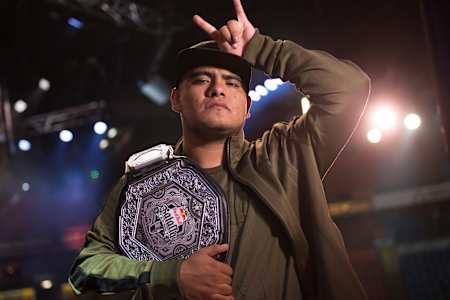 An image of Aczino posing with his world title belt after winning the 2017 Red Bull Batalla de Los Gallos World Final in Mexico City.