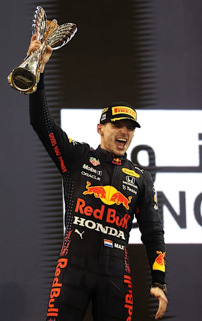 The Dutchman celebrates his world championship with a trophy and a jubilant smile.