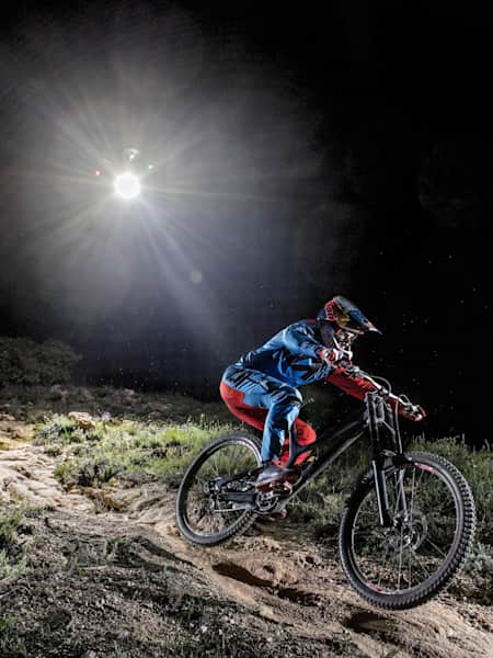 Le champion de VTT DH Loïc Bruni en descente sa piste maison de Mandelieu la nuit suivi par un drone équipé de LED dans la vidéo Night Chase.