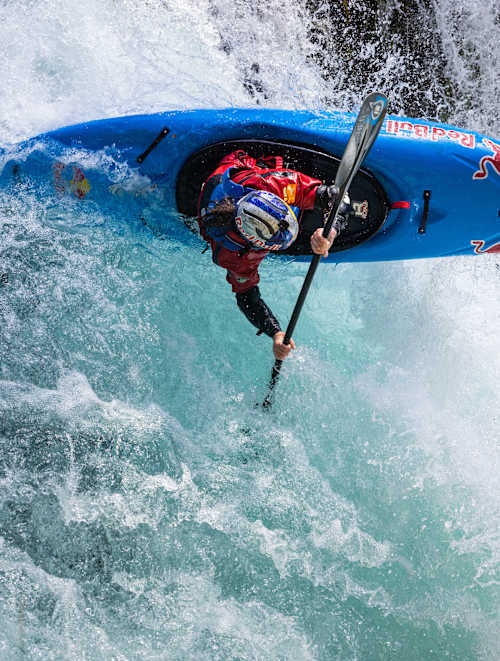 Nouria Newman, dans son kayak Red Bull, se lance dans une puissante chute d’eau lors d’un shooting photo en France en 2022, illustrant toute l’intensité du kayak en eaux vives.
