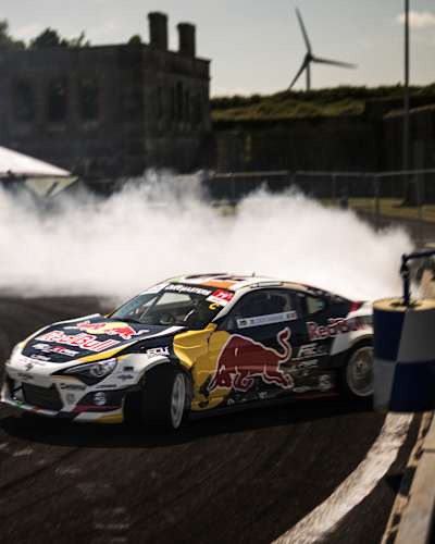 Conor Shanahan drifts his Red Bull car with precision on Spike Island, Cork, in 2025, surrounded by tyre smoke and high-octane excitement