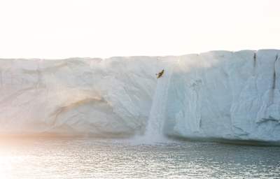Aniol Serrasolses kayaks on the 20m tall waterfall from the Austfonna ice cap to the Arctic Ocean, Svalbard on August 8, 2023.