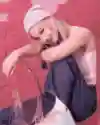 Ibuki sitting on a chair with a pink wall in the background