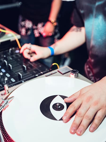 A photo of DJ Esta performing on record decks in Auckland, New Zealand, in 2016.