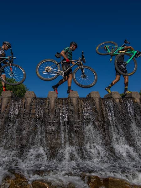 El paso de una presa en una de las etapas de Transcumbres MTB se tiene que hacer con la bici a cuestas.