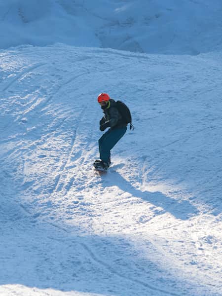 A snowboarder goes down the mountains in Gulmarg, Kashmir.
