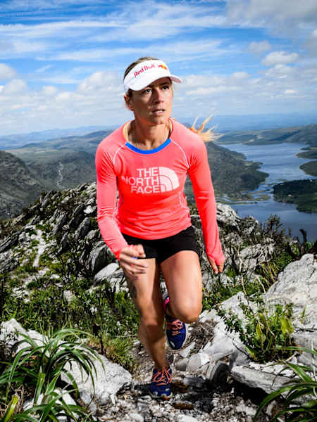 An athlete runs along a mountain ridgeline.