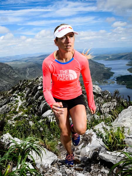 An athlete runs along a mountain ridgeline.