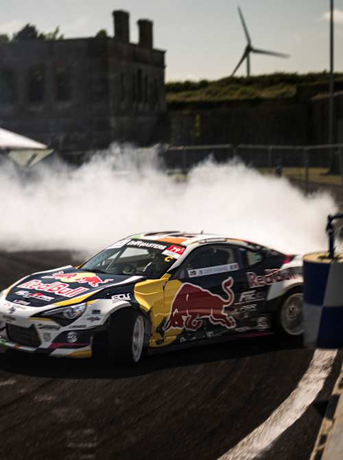 Conor Shanahan drifts his Red Bull car with precision on Spike Island, Cork, in 2025, surrounded by tyre smoke and high-octane excitement