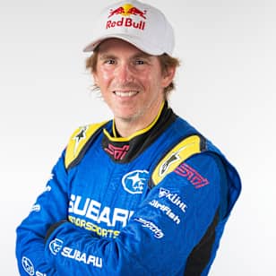 An image of racing driver Scott Speed in racing uniform and Red Bull cap.