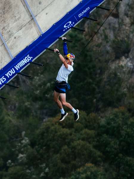 Thomas van Tonder hangs from the Red Bull Bridge Bars at Bloukrans Bridge, South Africa, in October 2026, high above the forested gorge.
