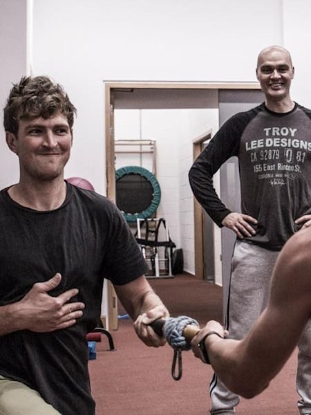 Dos atletas realizan un ejercicio.