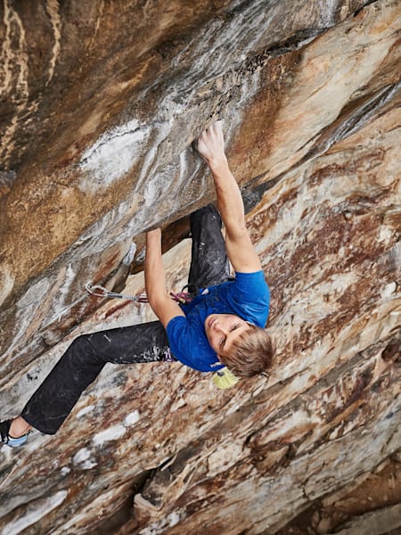 Alexander Megos beim Klettern in einer steilen Wand.