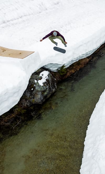 Ryan Decenzo traverses a frozen river creek gap with a huge kickflip