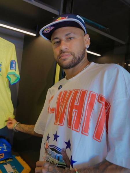 Neymar Jr qui montre son maillot de l'équipe nationale du Brésil.