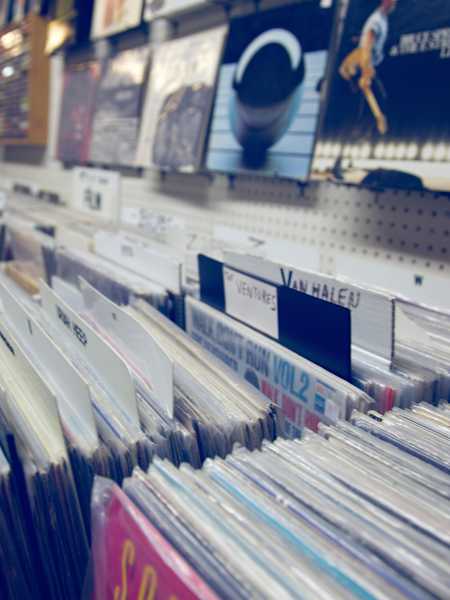 A photo of vinyl records in record shop racks.