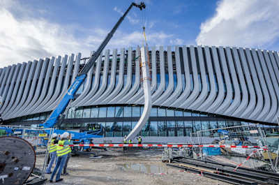 Ein Baukran hebt eine Lisene auf die Außenfassade des SAP Garden.