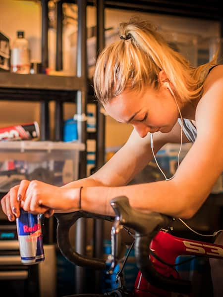 La cycliste professionnelle Tahnée Seagrave fait des exercices sur un home trainer pendant une séance d'entraînement.