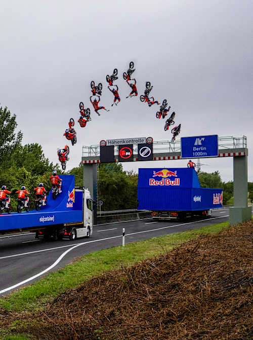 Luc Ackermann saute par-dessus une barrière de contrôle de hauteur avec un tsunami backflip sur son vélo FMX en Allemagne.