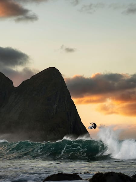 Surfer Mick Fanning surfing at sunset in the frigid waters off Lofoten, Norway.