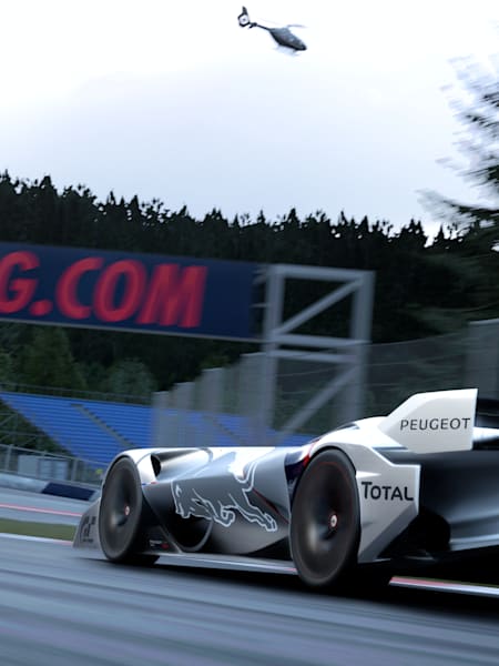 A Peugeot L750R Hybrid Vision Gran Turismo takes a long corner on the Red Bull Ring in the game Gran Turismo 7.