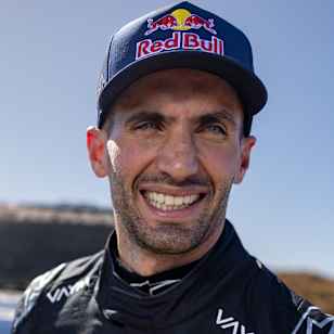 In San Juan, Argentina, Kevin Benavides gears up for Desafio Ruta 40 2026, smiling beside his Red Bull branded Hilux T1+ rally car during pre-event testing.