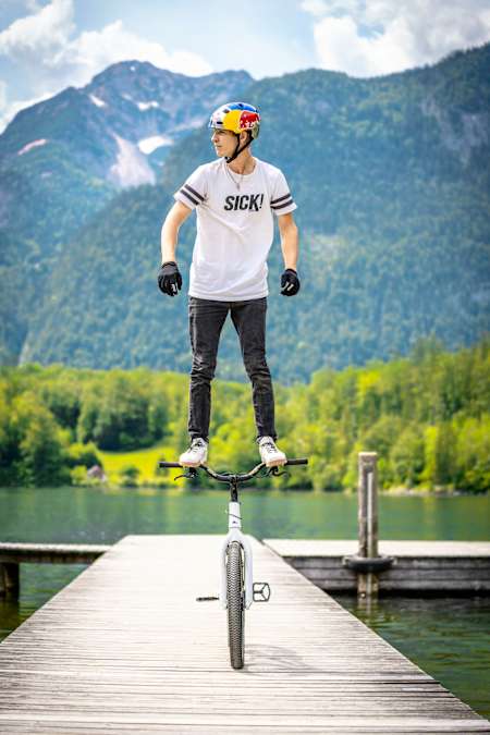 Trials biker Fabio Wibmer balances on the handlebars of his bike on the jetty at Lake Hallstatt, Austria.