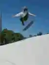 Skateboarder doing a kickflip at a skate park