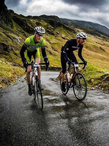 Twee fietsers op hun mountainbikes rijden een berg op.