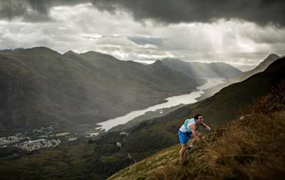 A runner scrambles up a mountainside in the UK.