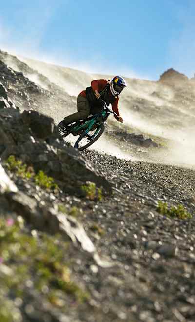 Brage Vestavik Riding his Mountain bike down a steep mountain at sunset in Sutton , Alaska, USA on July 15, 2024.