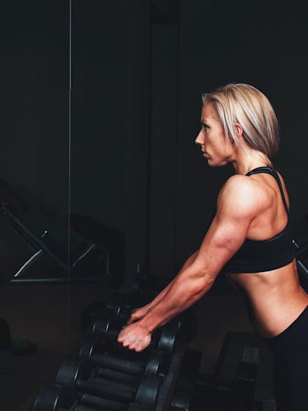 An athlete spinning in front of a gym mirror.