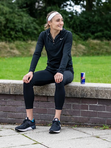 Zawodniczka Red Bull Pro Niamh Emerson siedzi na murku z puszką Red Bulla na Uniwersytecie Loughborough