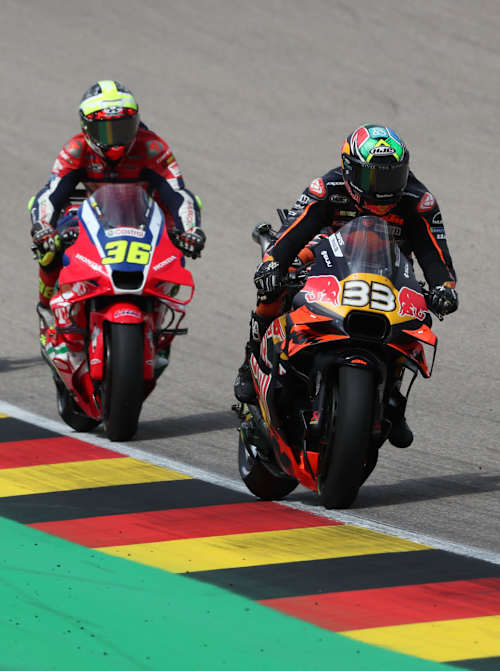 Gefolgt von drei weiteren Fahrern fährt Brad Binder am 13. Juli 2025 beim MotoGP™ am Sachsenring in Deutschland auf seinem Red Bull KTM Factory Racing-Motorrad