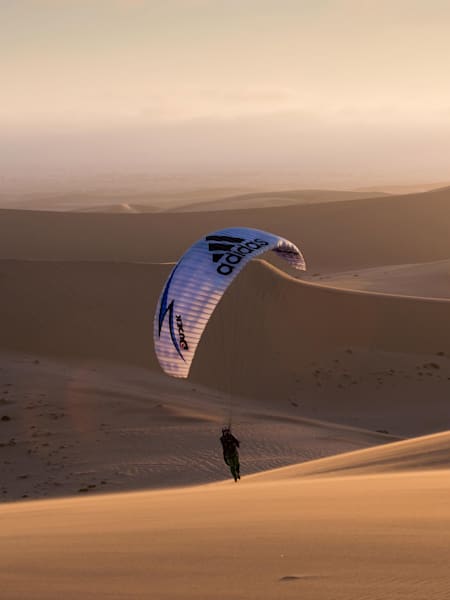 JB Chandelier et Tim Alongi frôle le sable en parapente dans le désert de Namibie.