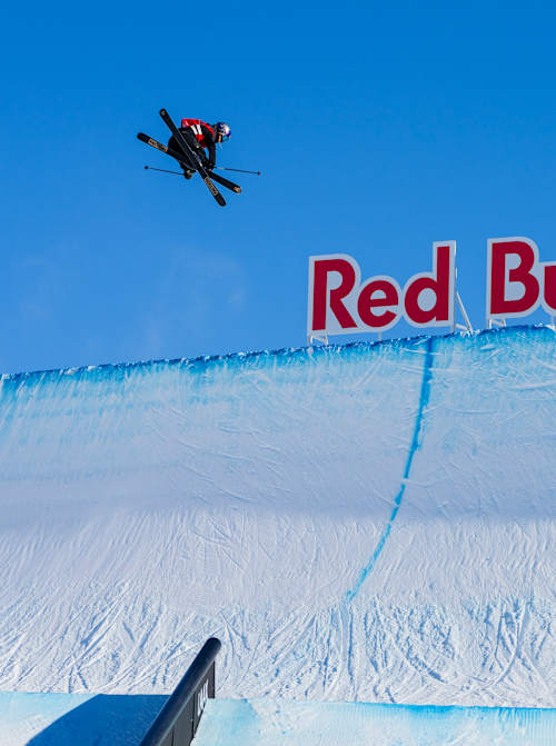 Eileen Gu performs daring aerial tricks against a backdrop of the iconic Red Bull logo at the Laax Open 2025.