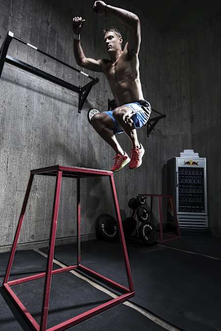 Een sporter springt tijdens zijn box jumps sessie op een verhoog.