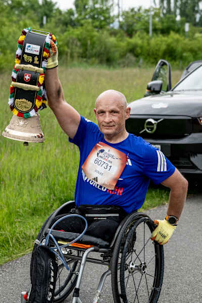 Witold Misztela, de Pologne, soulève fièrement le trophée du vainqueur après avoir conquis 57 km lors de la Red Bull Wings for Life World Run à Zug, en Suisse, 2026