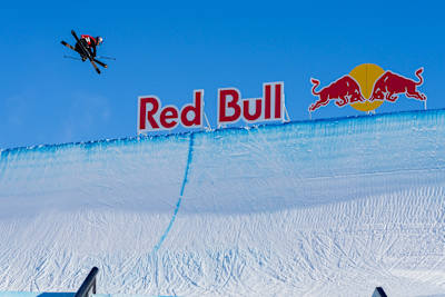 Eileen Gu performs daring aerial tricks against a backdrop of the iconic Red Bull logo at the Laax Open 2025.