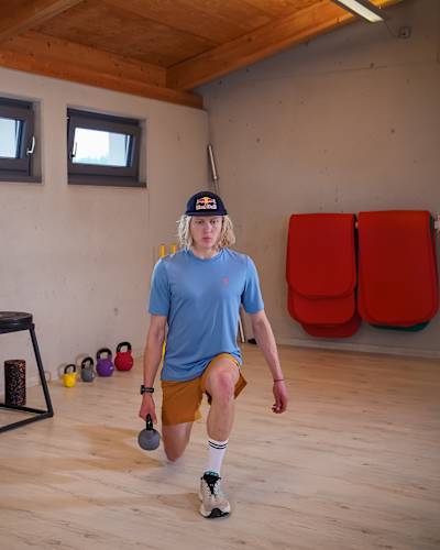 Triathlet Mika Noodt macht für ein Fotoshooting den Bewegungsablauf für einen Backward Lunge mit Kettlebell vor. Eine seiner Lieblingsübungen für die Beine.