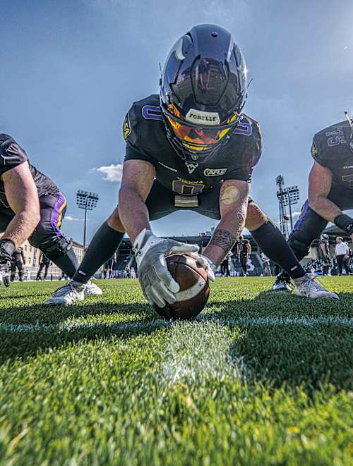 Fünf Spieler der Vienna Vikings kauern in einer Angriffsreihe, einer hält den Ball.