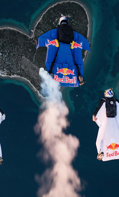 Marco Waltenspiel, Amy Chmelecki and Marco Fuerst fly with their wingsuits over the heart island near Zadar, Croatia, November 30, 2016