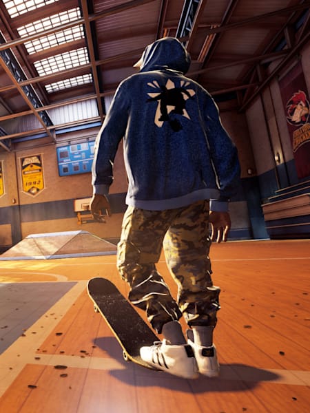 Ein Skater steht mit dem Rücken zur Kamera in einer Skateboard-Halle