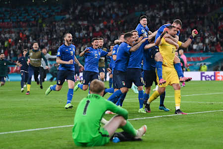 Gianluigi Donnarumma of Italy celebrates with teammates after saving the England fifth penalty taken by Bukayo Saka in the Euro 2020 Final at Wembley Stadium on July 11, 2021 in London, England.