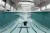 A high-diver slows down quickly underwater using their arms.