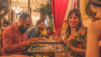 Mesa de dos jugando al tradicional juego de palabras Scrabble