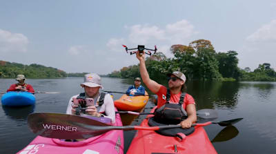 A kayaker launches a drone on the Ivindo River, Gabon.
