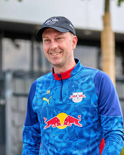 Ole Werner sorrindo enquanto usa um boné e o uniforme do RB Leipzig.
