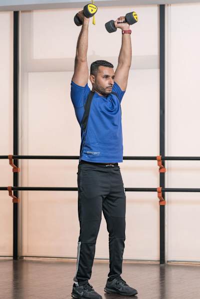 Flexiones de bíceps en martillo con press frontal de hombros con mancuernas